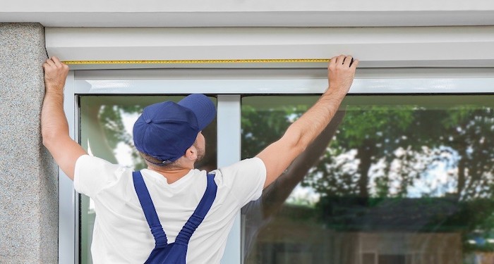 man measuring window outside